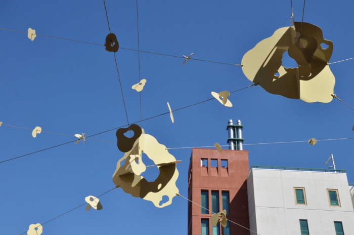 　作品名：「Sky Dancing」／作家：彫刻家・五十嵐威暢氏／撮影：Noreen Rei Fukumori
　五十嵐氏のコメント：「サンフランシスコ市のパブリックアートのプロジェクトです。アー
　ティストに選ばれてから、建築工事の遅れなど様々な理由で完成まで10年の道のりでした。
　金属の吊り彫刻は花と花びらのイメージ。解放されるような軽快感を狙いました。この他に
　も、同施設内に、テラコッタの壁彫刻や木とテラコッタの小作品が8点設置されています。」